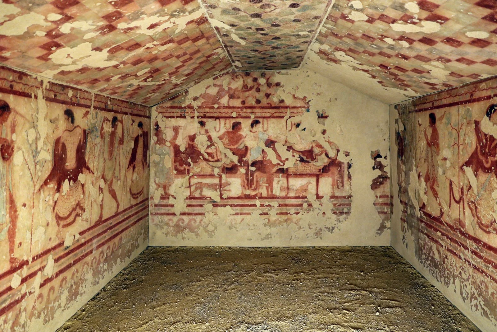 Painted interior of the Tomb of the Triclinium with banqueters and attendants on the walls.