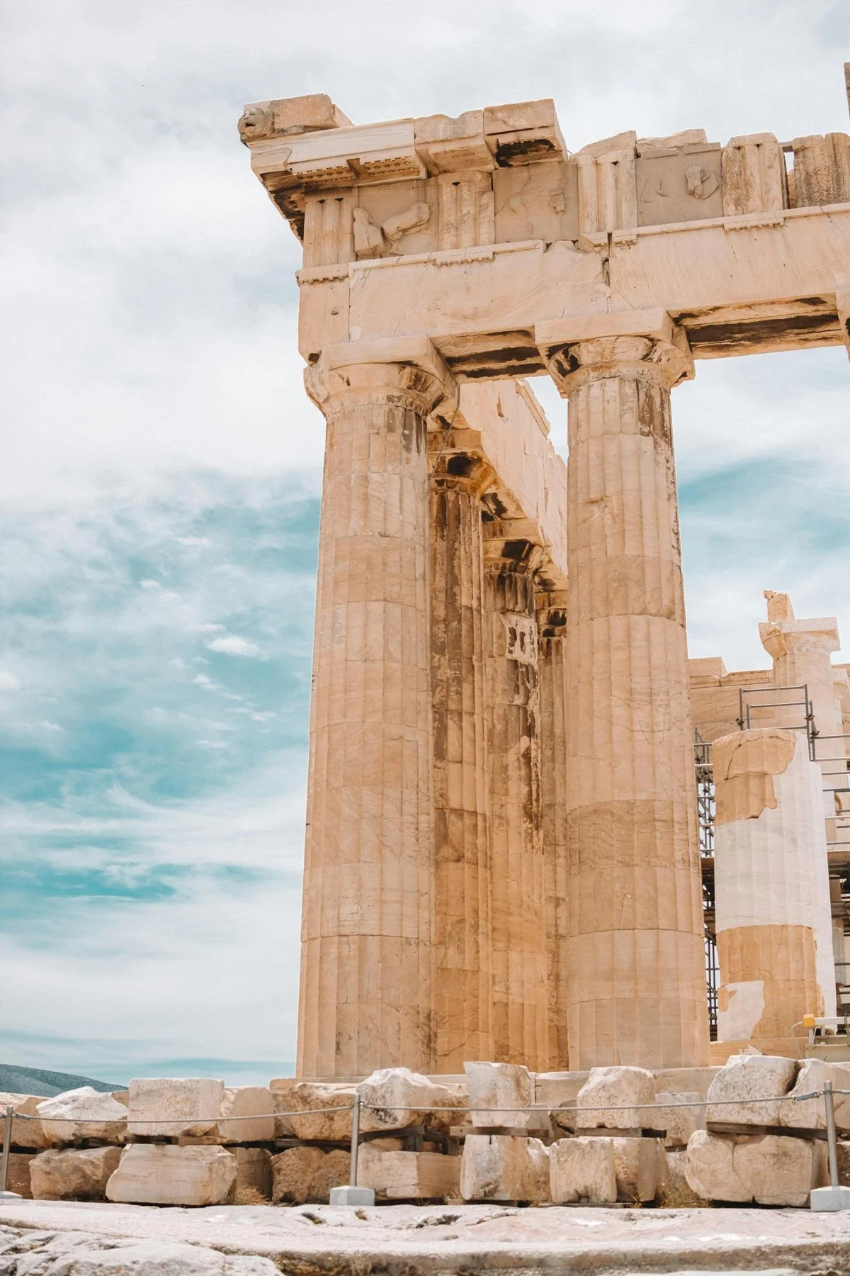 Corner detail of the Parthenon with columns, entablature, and weathered stone blocks.
