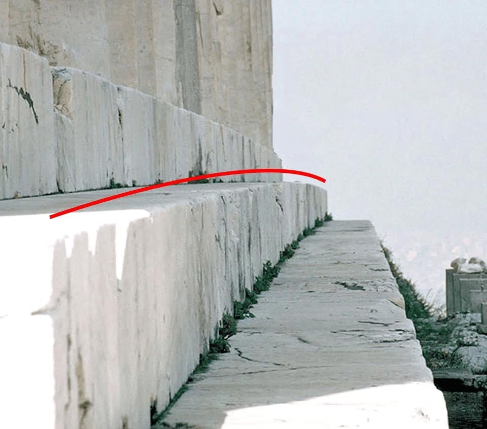Detail photo of the Parthenon stylobate with a red line marking its upward curve.