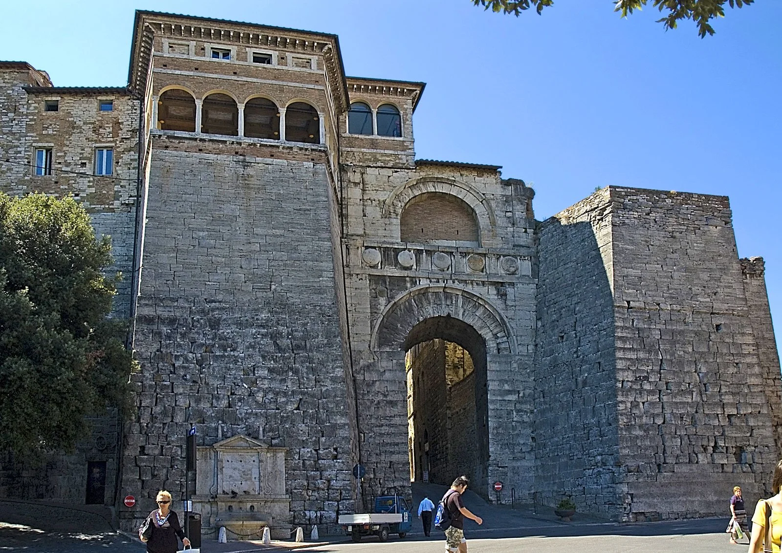 Stone view of the Etruscan Arch at Perugia with its arched gateway and flanking walls.