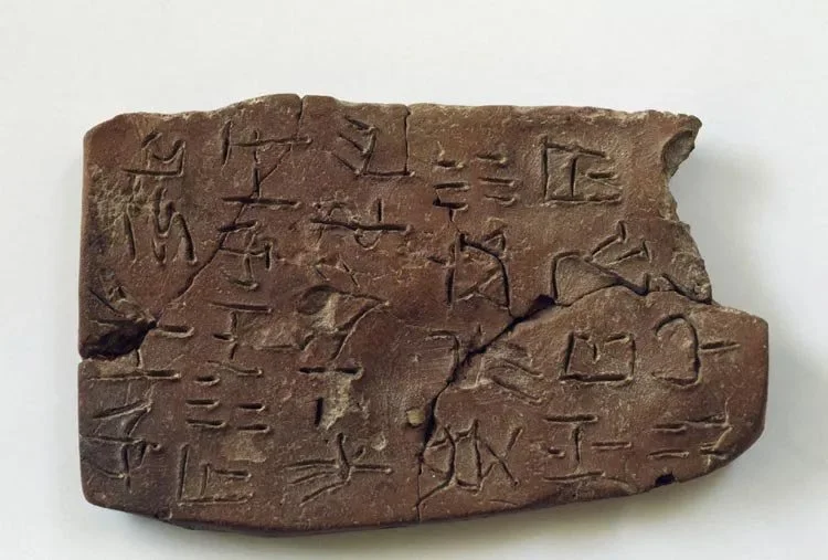 Small clay sealing (cretula) stamped and incised with Linear A signs from Archanes, Crete.