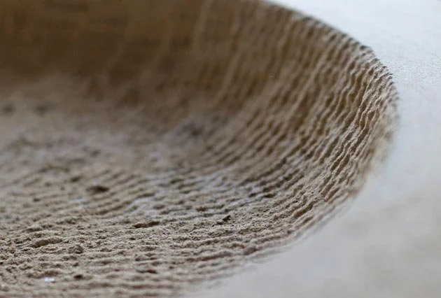 Close-up of parallel claw-chisel marks carved into a stone surface.