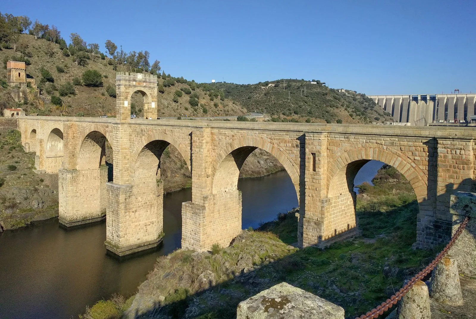 Stone Roman bridge at Alcántara crossing a river on high piers with broad arches.