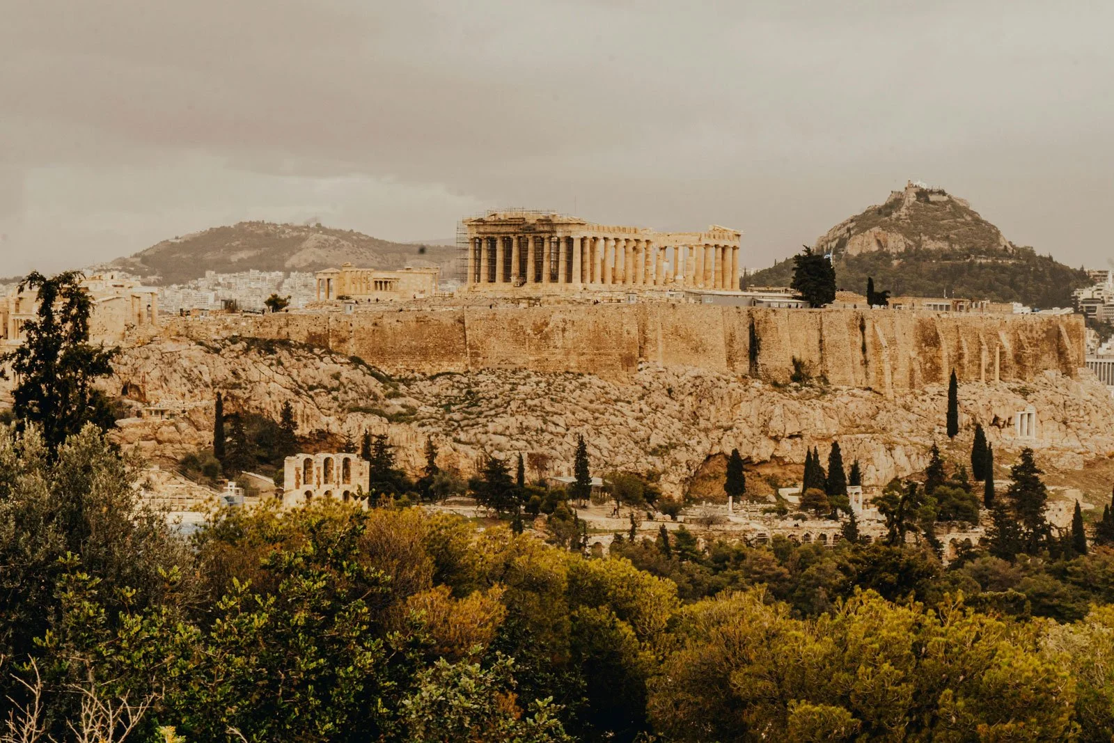 Distant view of the Acropolis hill rising above Athens with the Parthenon visible on top.
