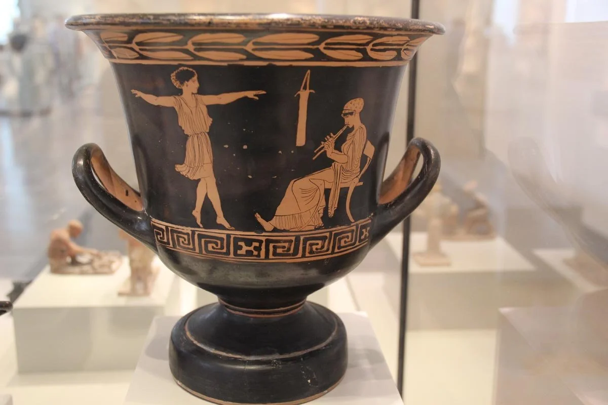 Red-figure calyx-krater by the Berlin Dancers Painter, with a girl dancing to a seated musician against a black ground.