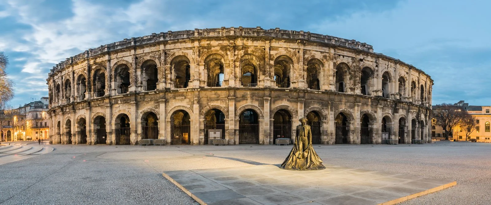Exterior view of the amphitheatre at Nîmes with its elliptical form and stacked arcades.