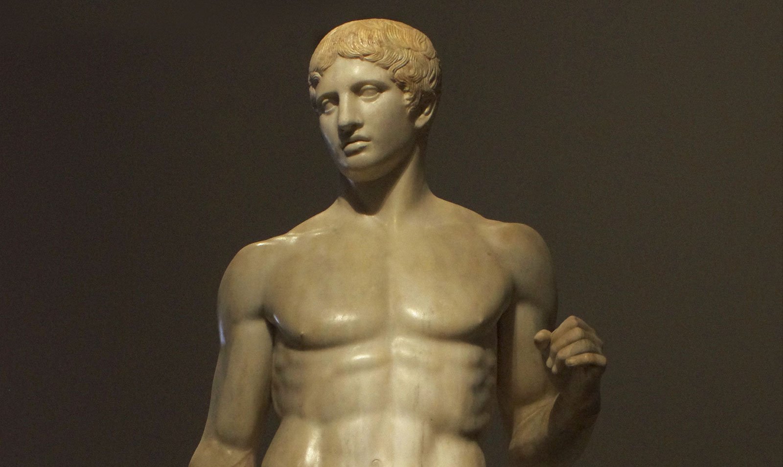 Close-up of the Doryphoros showing the head, chest, and raised arm of a marble athlete.