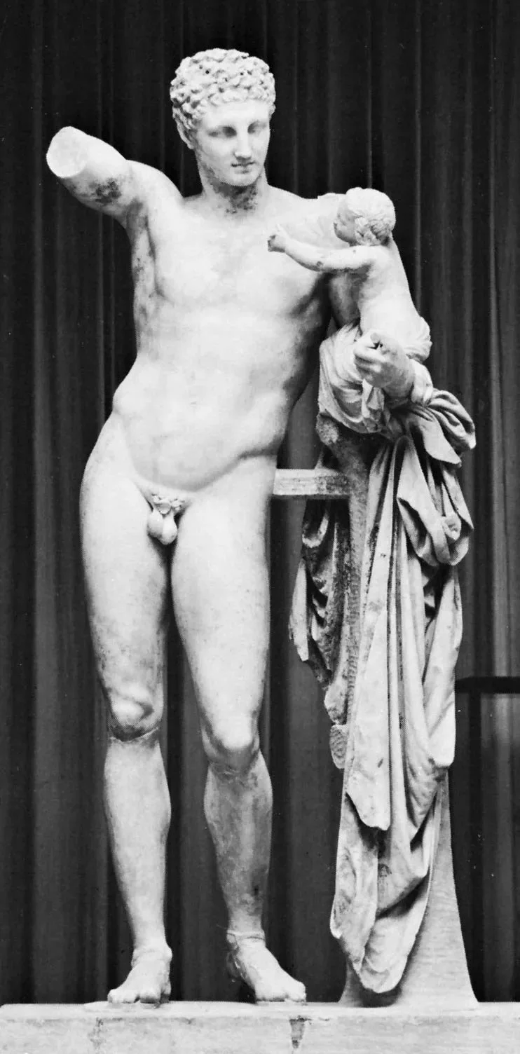 Marble statue of Hermes holding the infant Dionysus beside him, with drapery gathered over a support.
