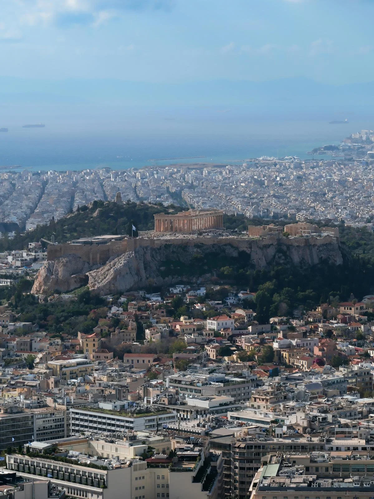 Wide view of the Acropolis and Parthenon rising above modern Athens.