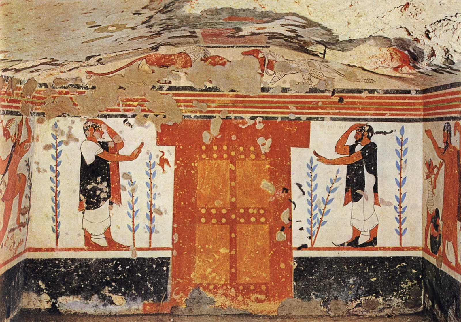 Painted interior of the Tomb of the Augurs with standing figures flanking a central doorway motif.