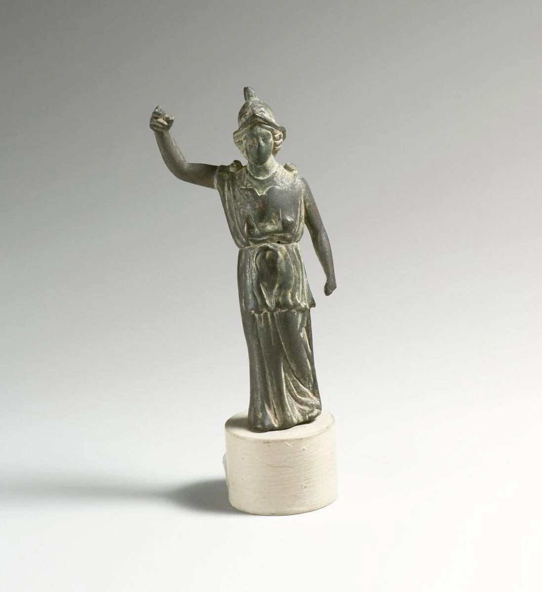 Small bronze statuette of Athena wearing a helmet and raising one arm.