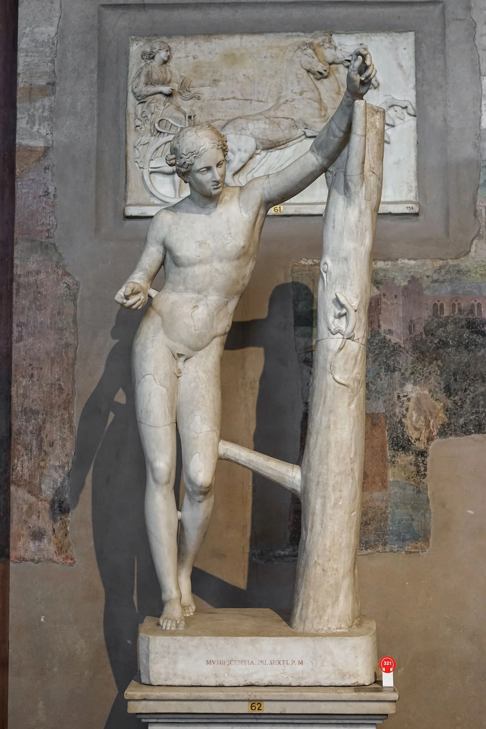Marble statue of Apollo leaning toward a tree trunk in the Sauroktonos pose.