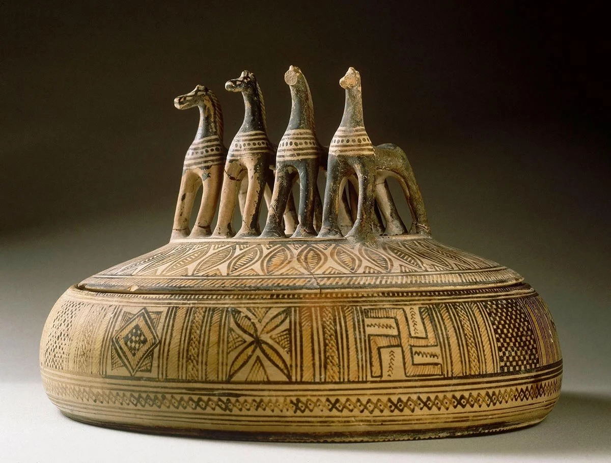 Geometric lidded pyxis with four standing horses on the lid and dense bands of patterns around the rounded body.