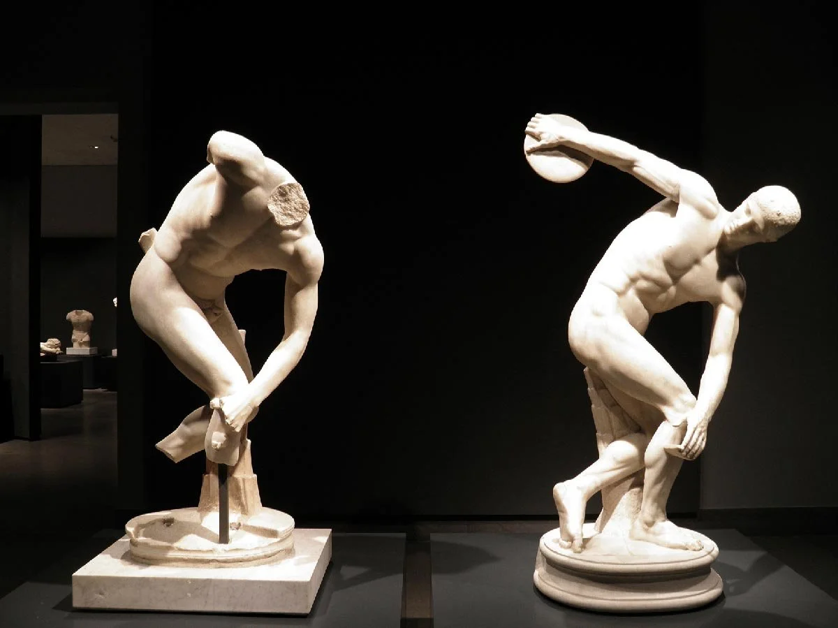 Two Roman copies of the Discobolus shown side by side, one complete and one fragmentary.
