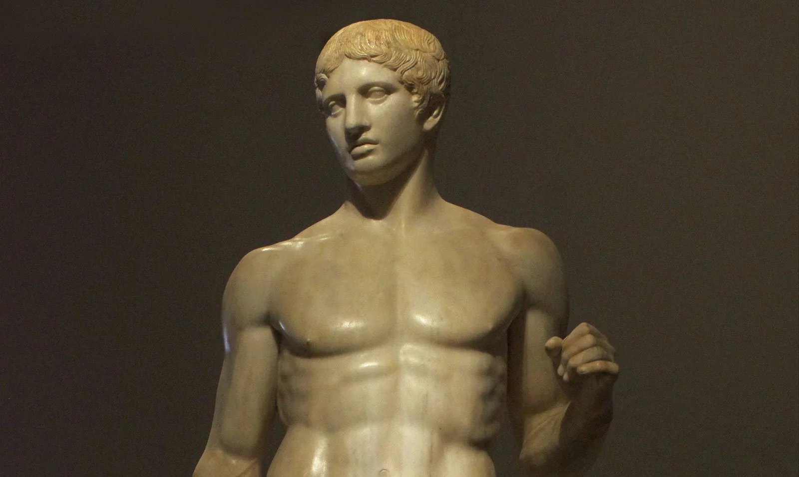 Close-up of the Doryphoros showing the head, chest, and raised arm of a marble athlete.