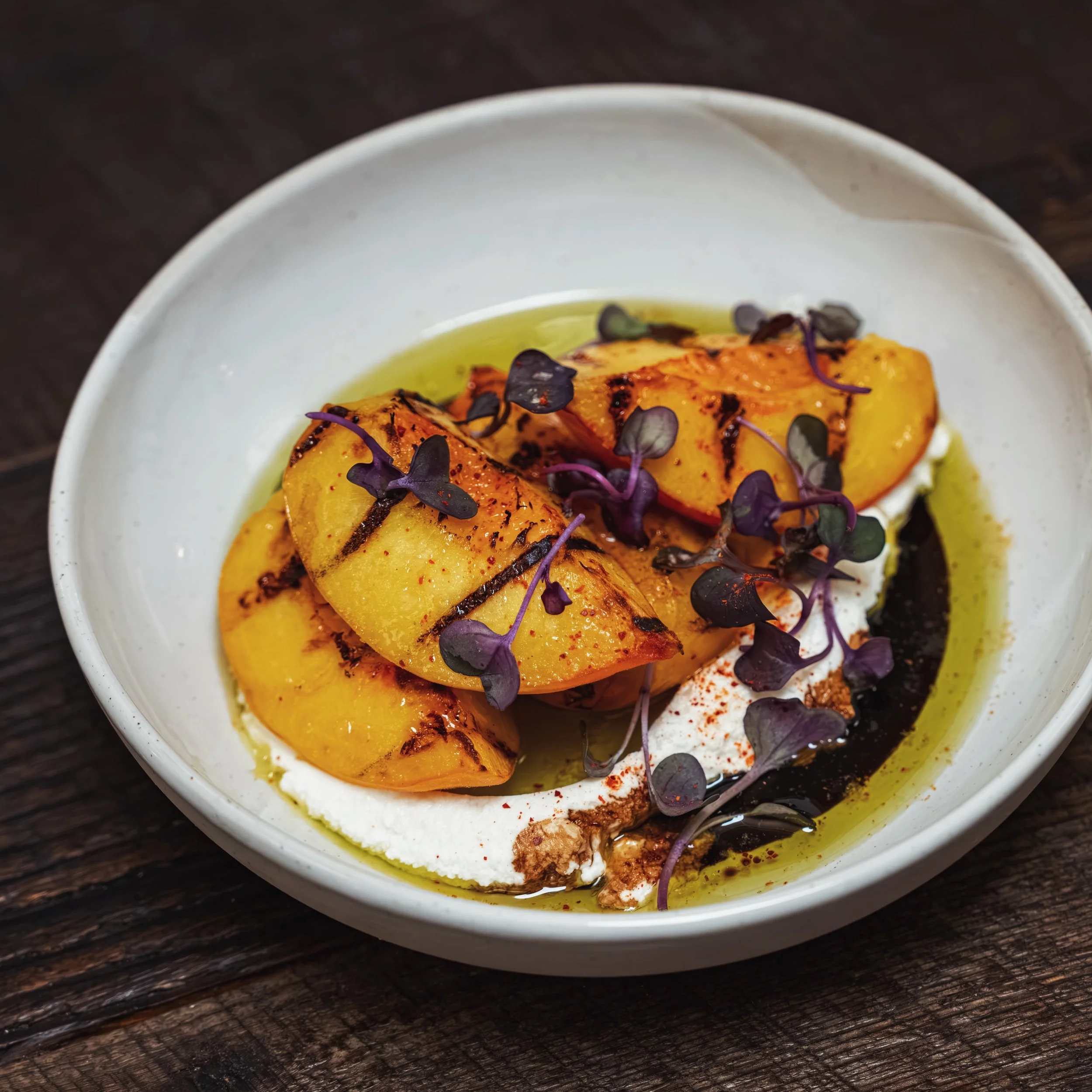 Black Bear peaches, grilled and paired with Drake&rsquo;s Farm ch&egrave;vre, pomegranate molasses, and thyme. Summer is still firing at Matilda.