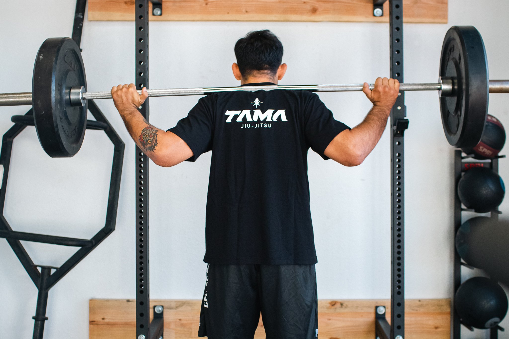 Athlete strength training with a barbell at Tama Jiu Jitsu in San Diego