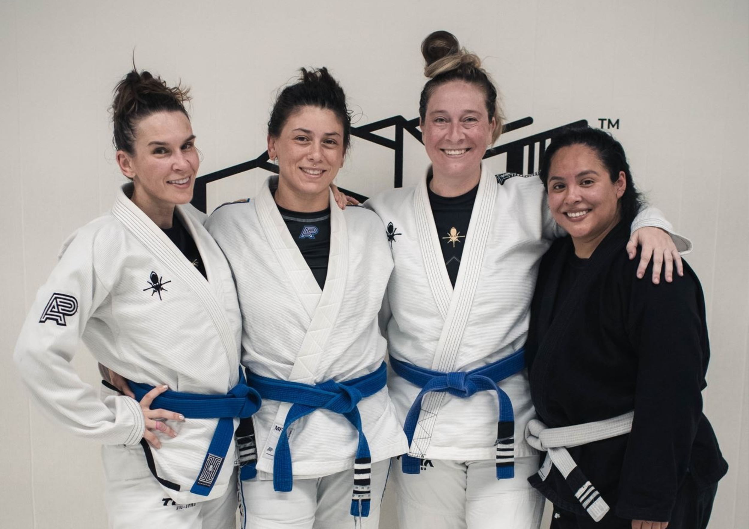 Four women Brazilian Jiu-Jitsu practitioners posing together in their uniforms and belts at Tama Jiu-Jitsu in San Diego, celebrating their progress and achievements in BJJ.
