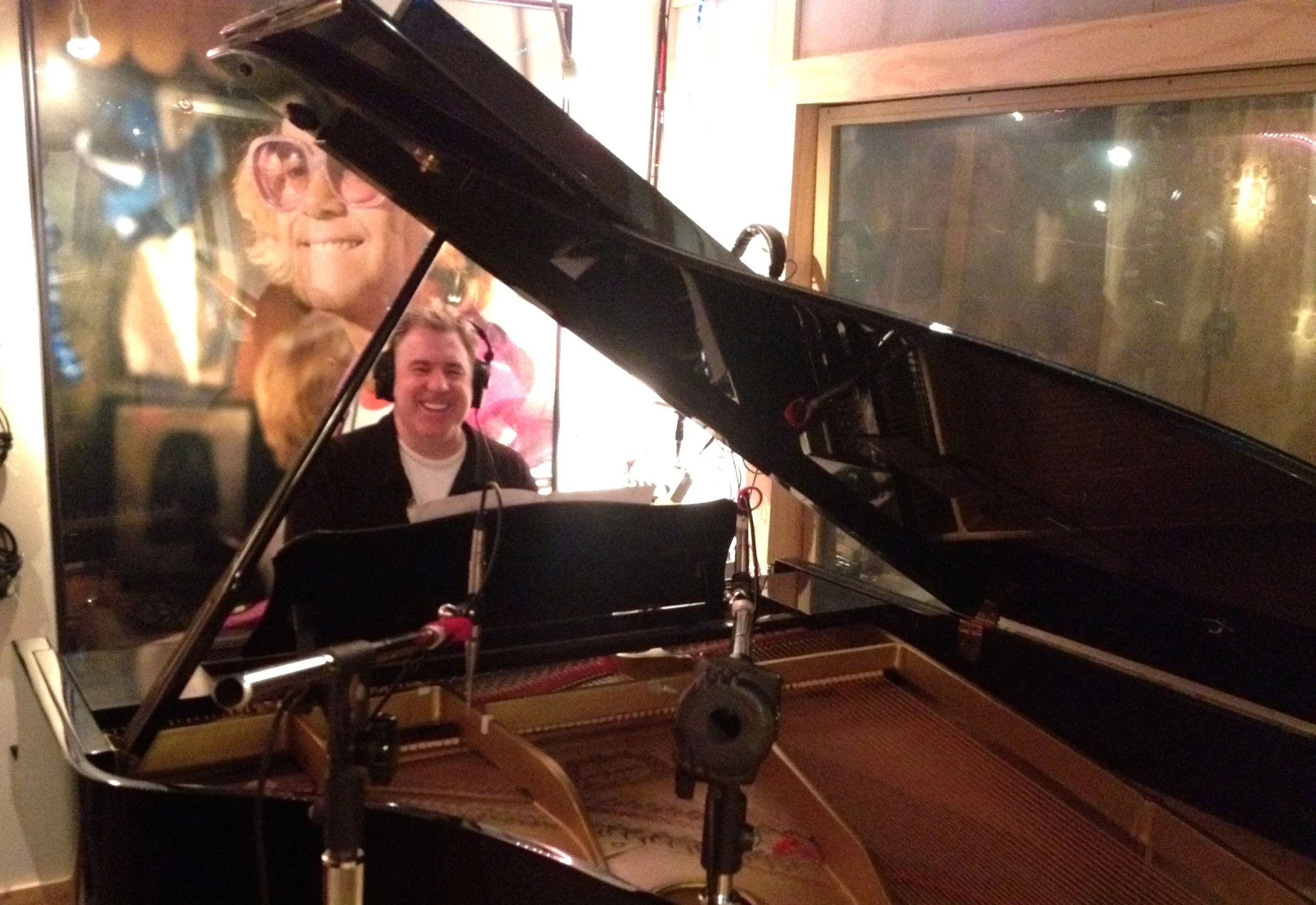 Shane Adams at a grand piano during a recording session