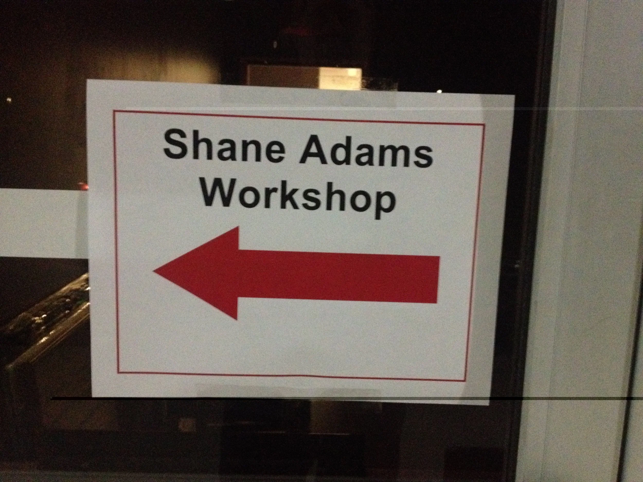 Sign pointing the way to a Shane Adams songwriting workshop