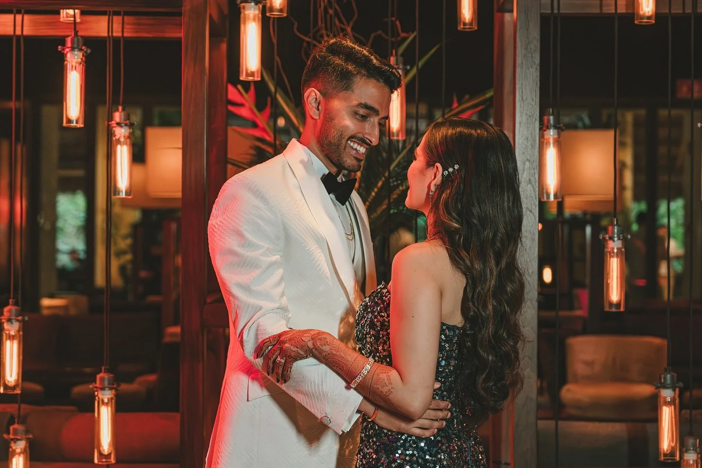 Newlyweds sharing a quiet moment in a warmly lit reception space, planned by Preeti Exclusive Events.