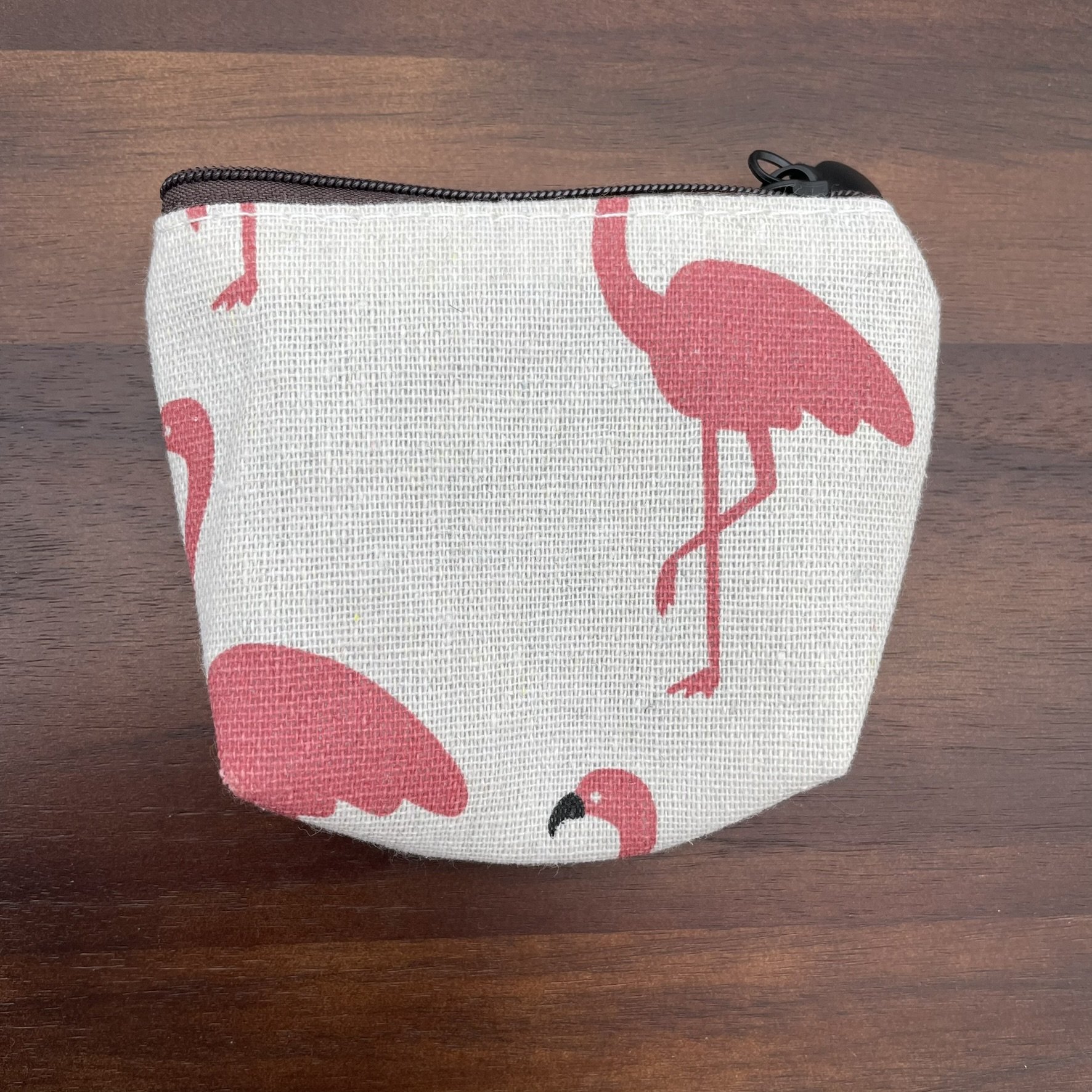 Small fabric pouch with pink flamingo design, featuring a zipper closure.