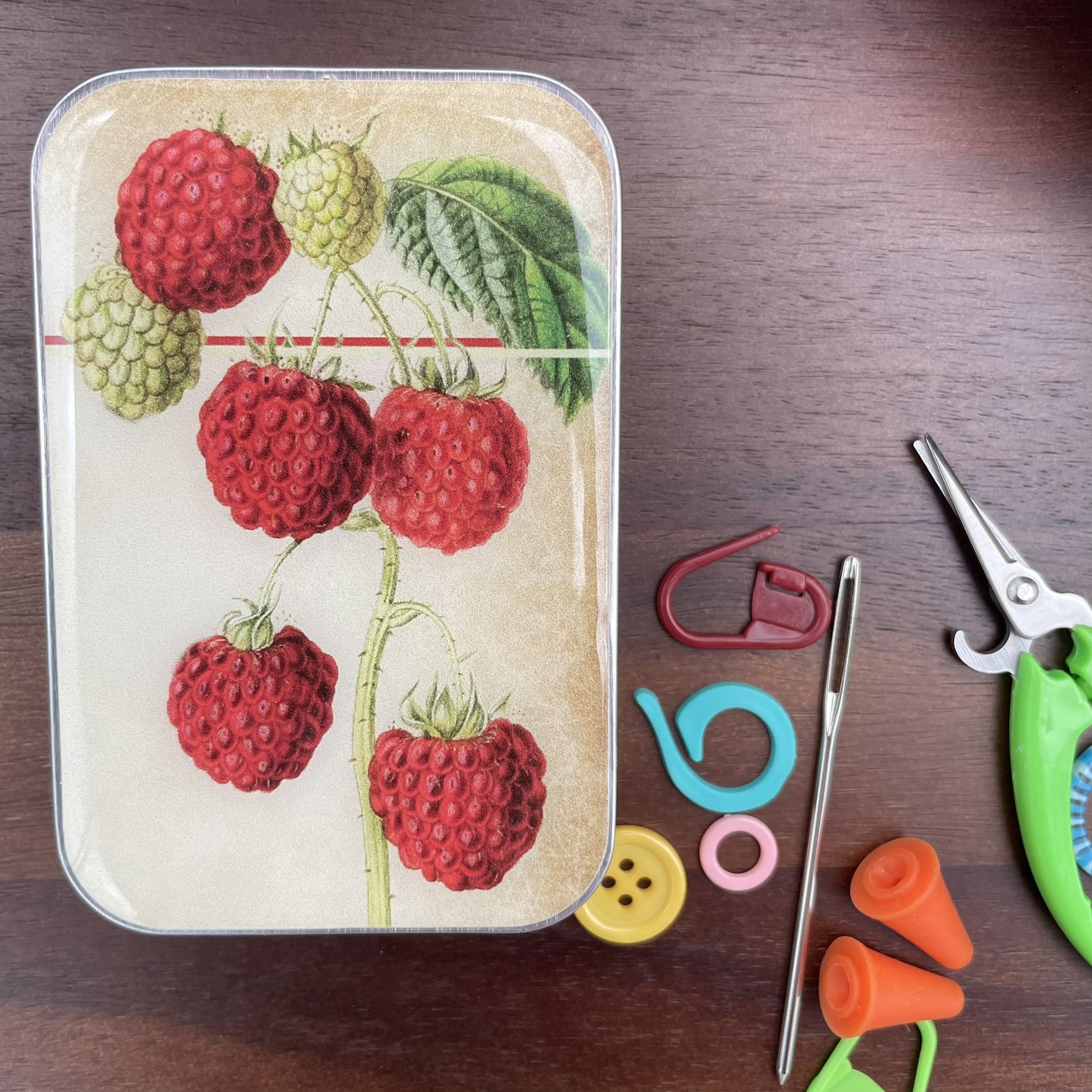 Firefly Notes notions tin with vintage raspberry design, top view.