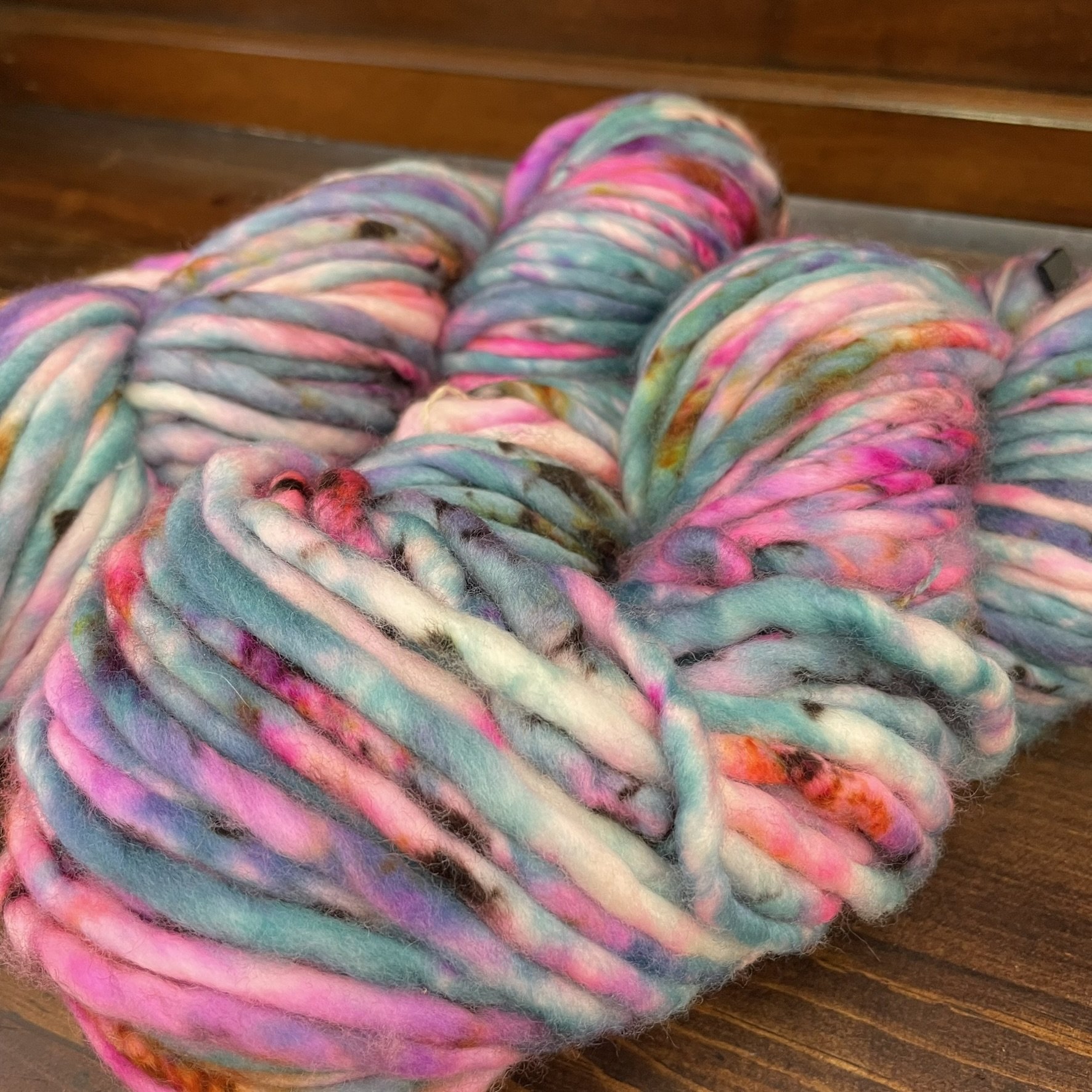 Close-up of Honey & Clover Super Bulky Silent Lucidity yarn, displaying soft pastel shades in blue, pink, and white.