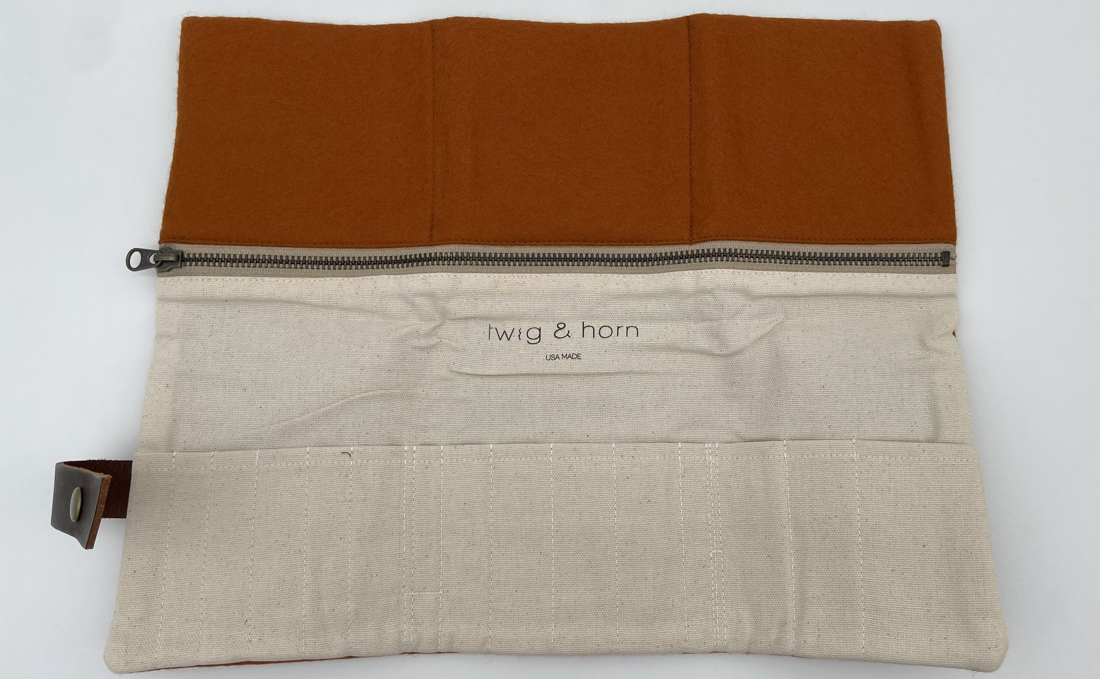 Twig & Horn orange wool knitting tool pouch fully opened, showcasing multiple storage compartments and zippered pocket.