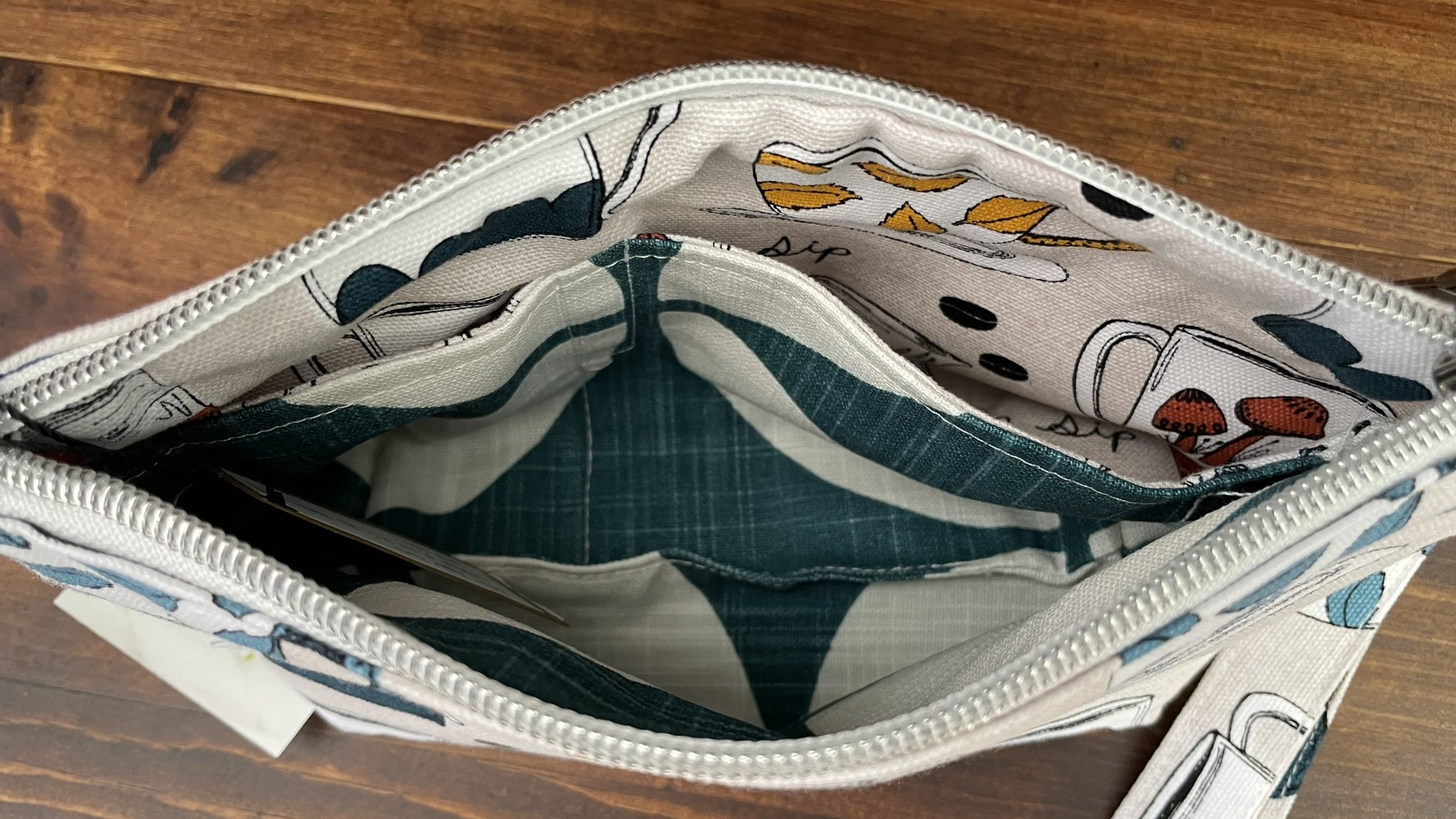 Interior view of the zippered coffee mug print pouch, featuring a spacious compartment with a colorful fabric lining.