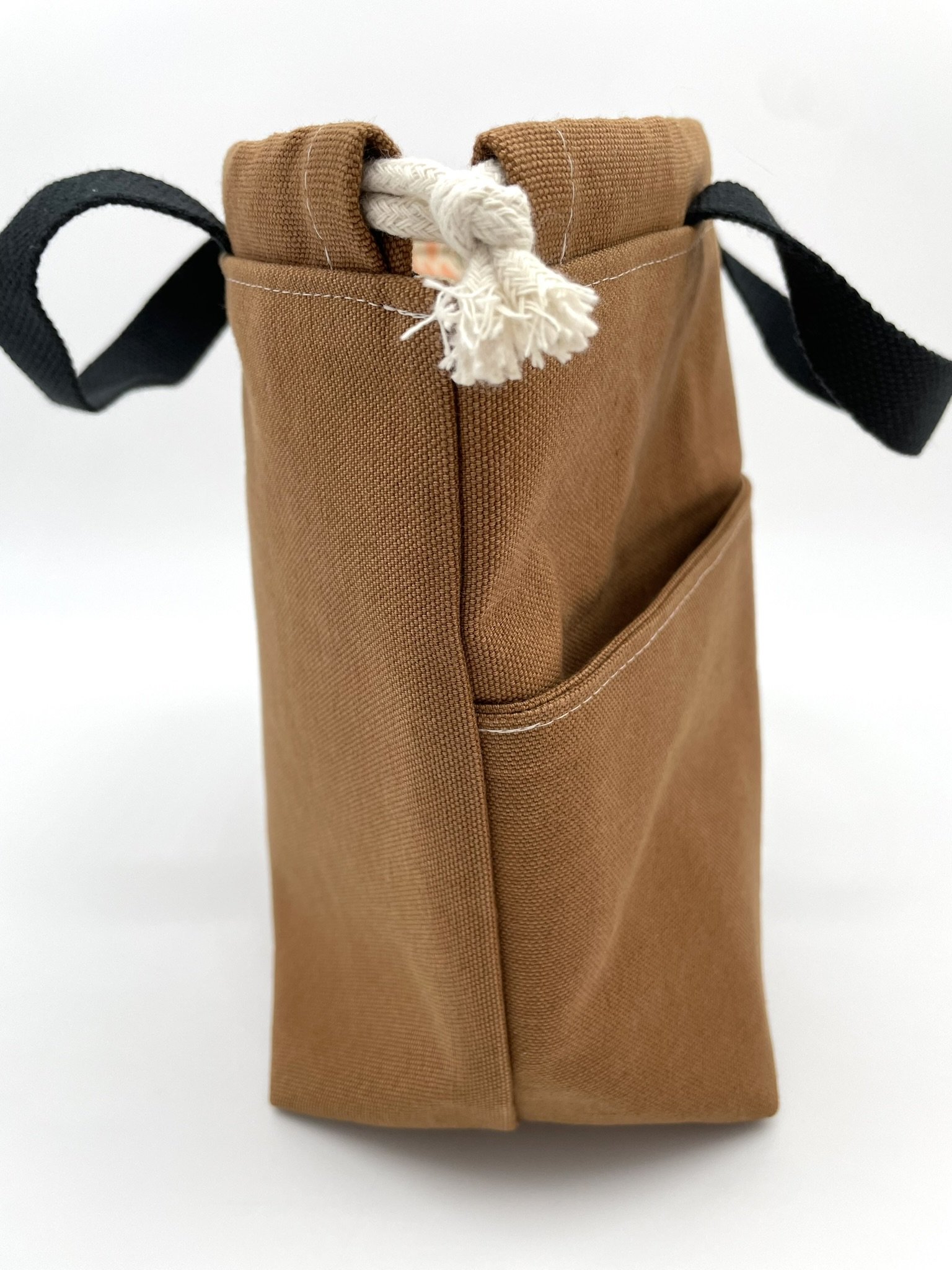 Side view of the small brown Puff Stitch project bag, highlighting the drawstring closure.