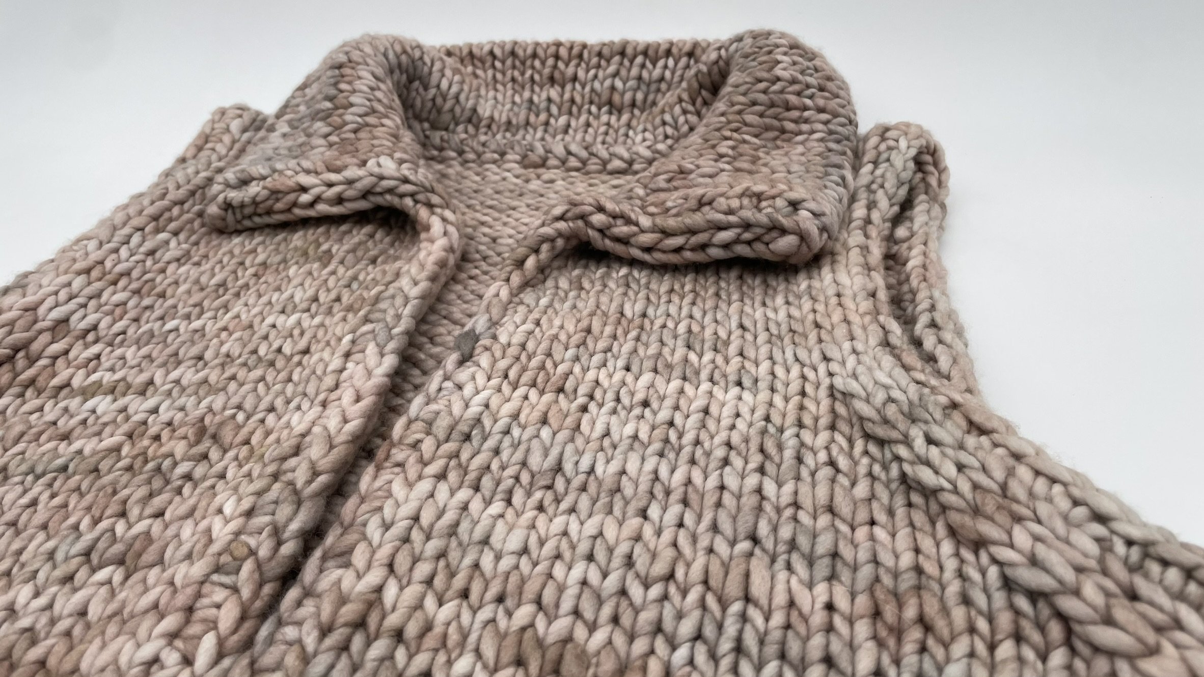 Angled view of the folded collar on a hand-knit adventurer vest.