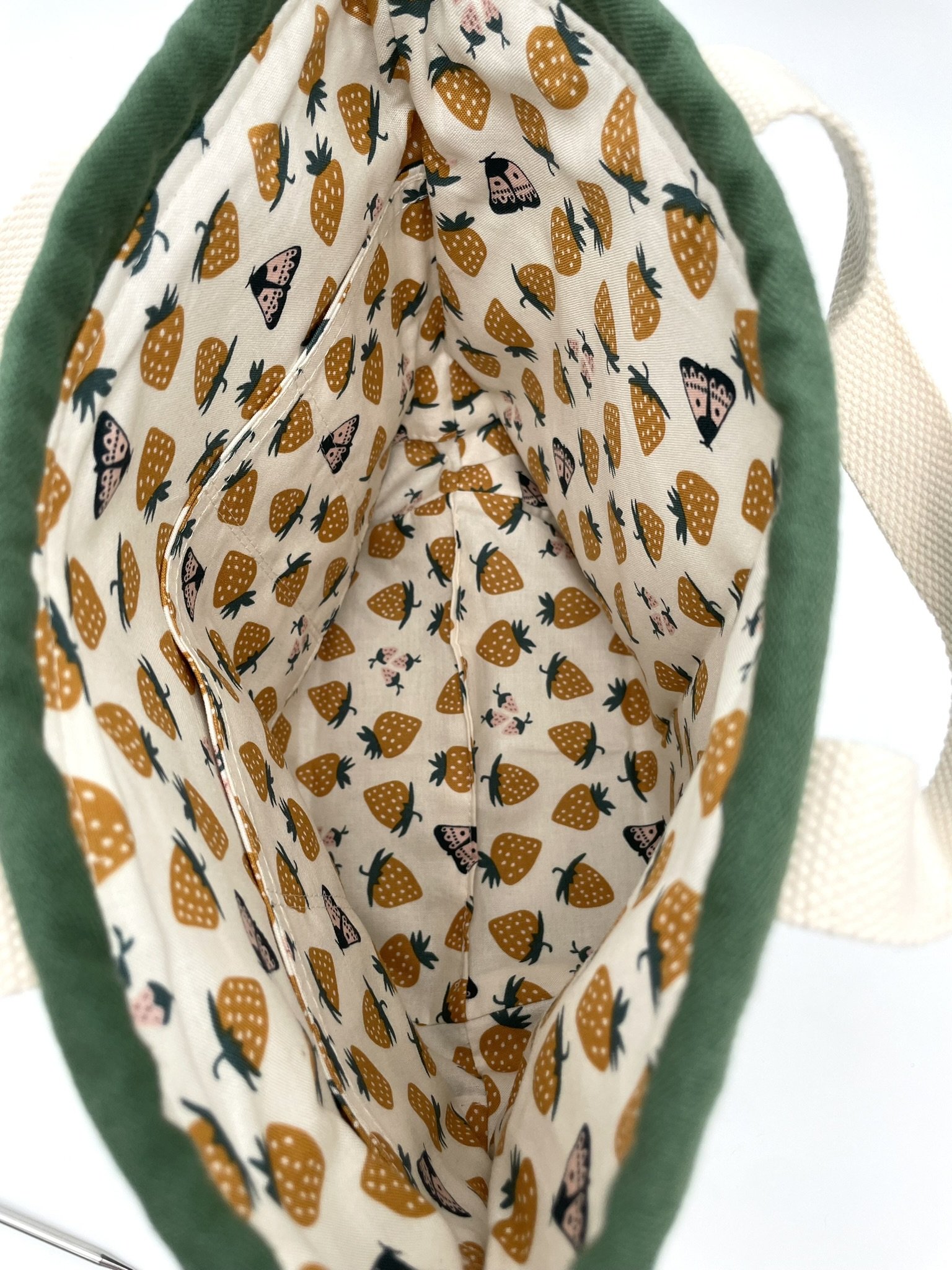 Inside view of the small green Puff Stitch project bag with strawberry-patterned fabric.