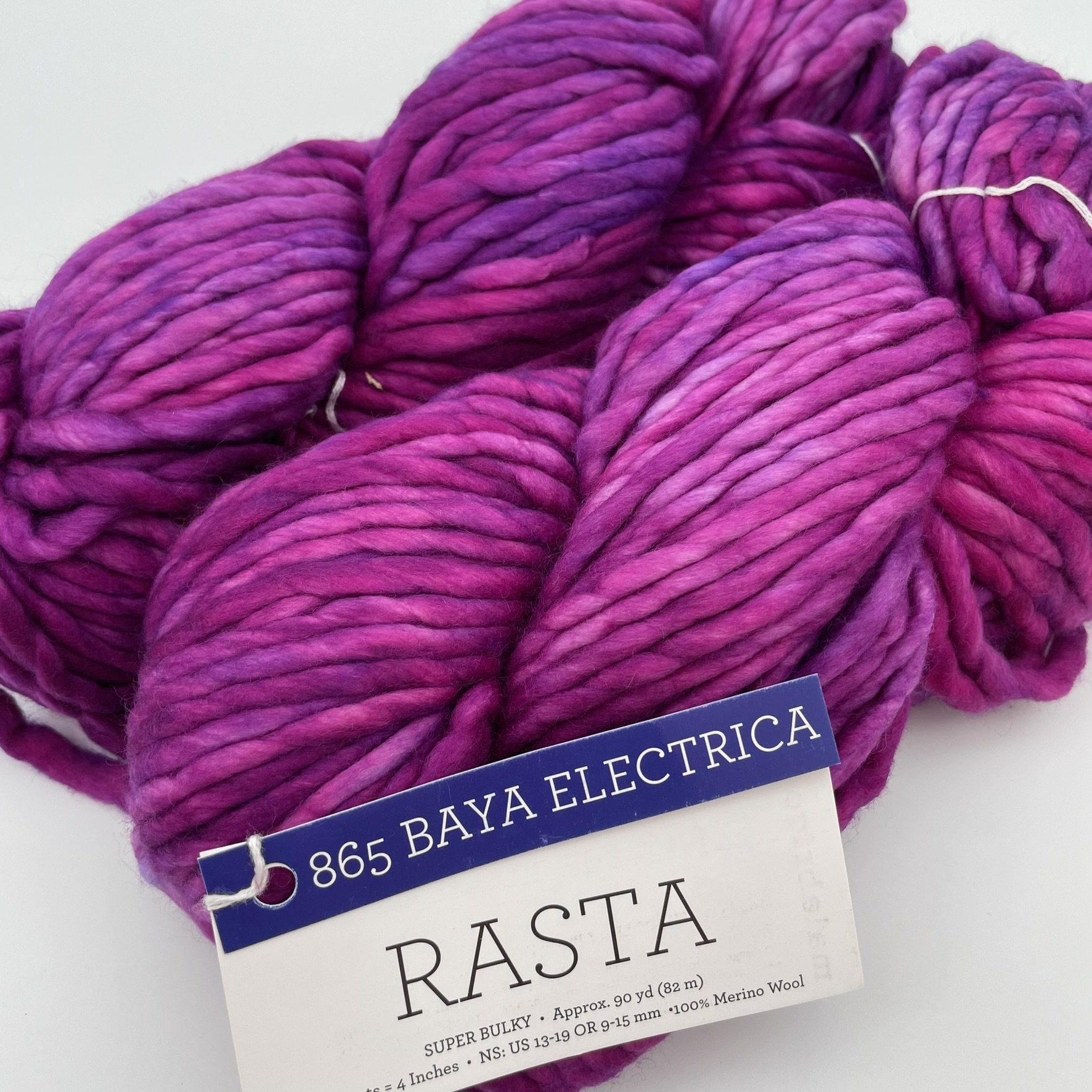Malabrigo Rasta yarn in Baya Electrica colorway, featuring bright purple and pink shades in super bulky merino wool.