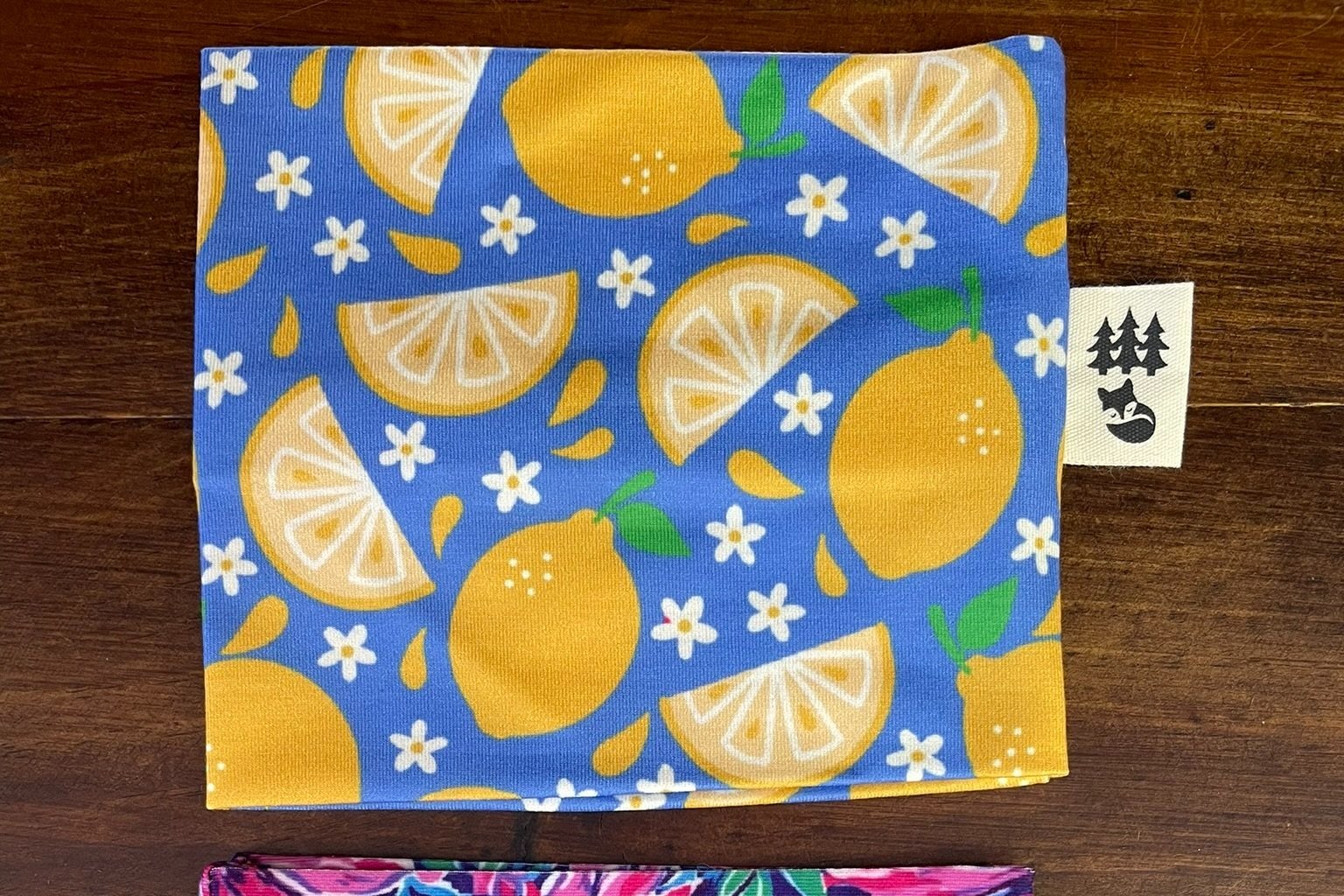 Fox & Pine yarn sweater in a vibrant lemon print on a blue background, showcasing sliced lemons and white floral details.