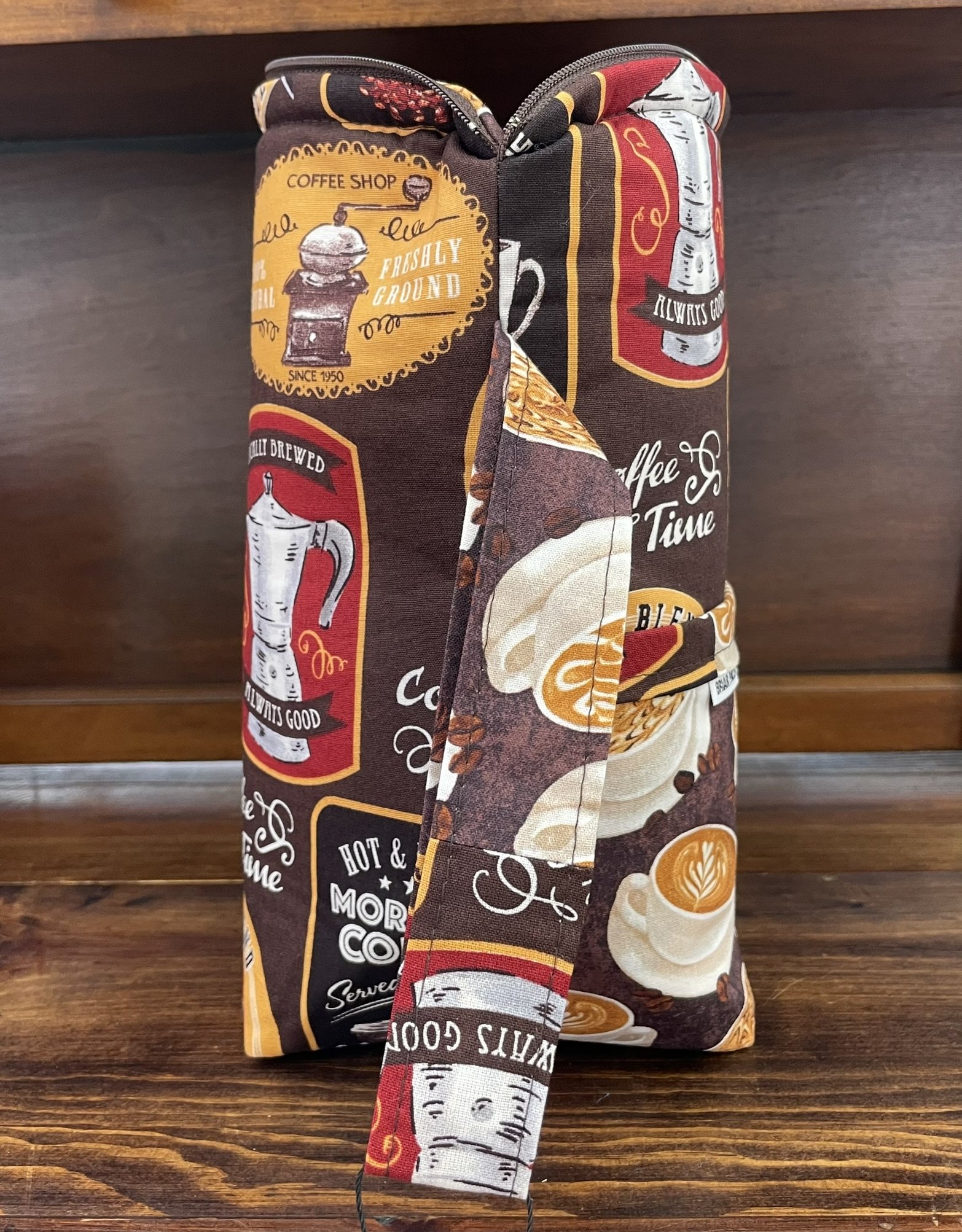 Side view of a large coffee-themed project bag with a sturdy handle, displaying coffee-themed fabric with vintage designs.