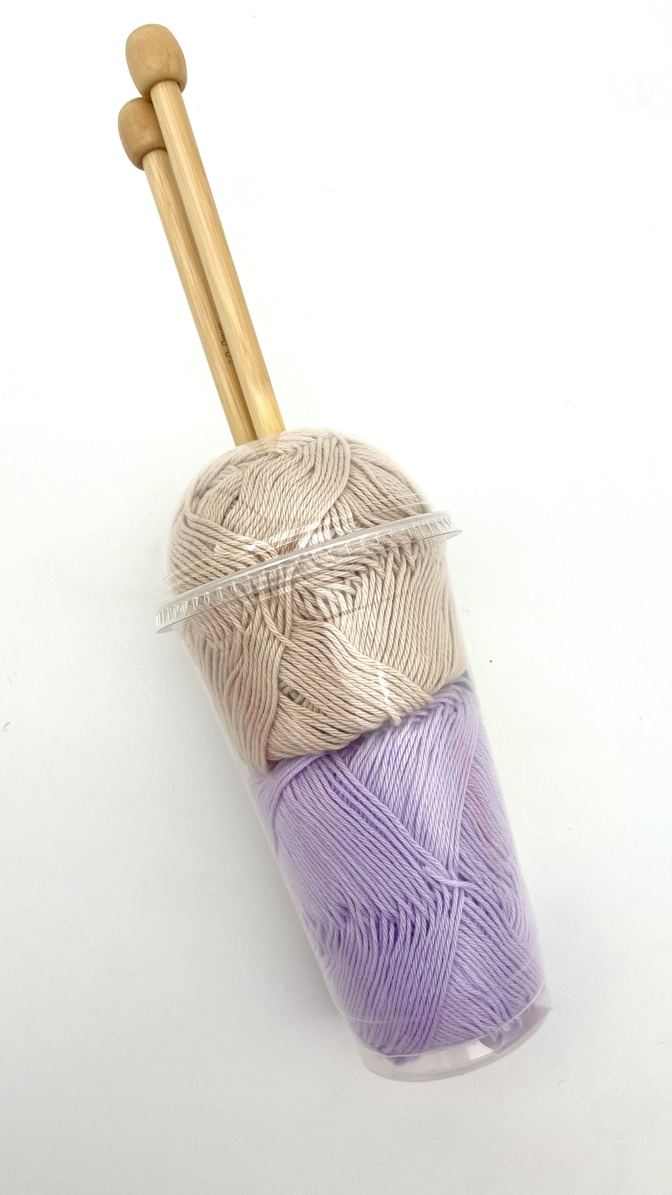 DIY Smoothie Scarf Knitting Kit by Knitca showing tan and purple yarn in cup packaging with wooden knitting needles