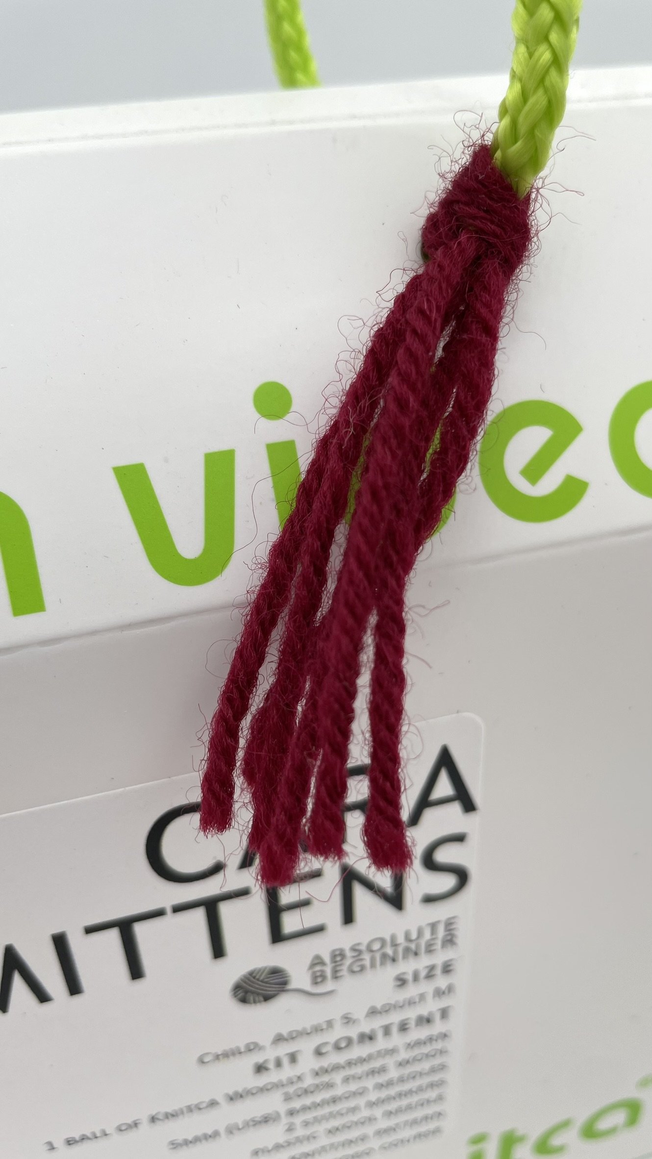DIY Knitting Kit for Cara Mittens by Knitca featuring burgundy yarn and bamboo knitting needles, ideal for beginners.