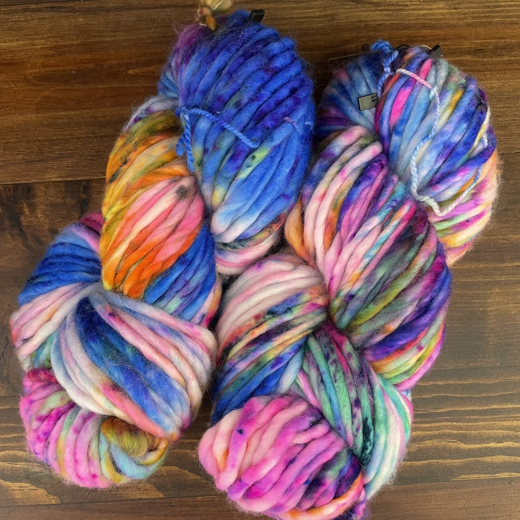 Overview of Honey & Clover Super Bulky yarn in I Can't Feel My Face, showcasing a combination of bright pink, blue, purple, and green hues.