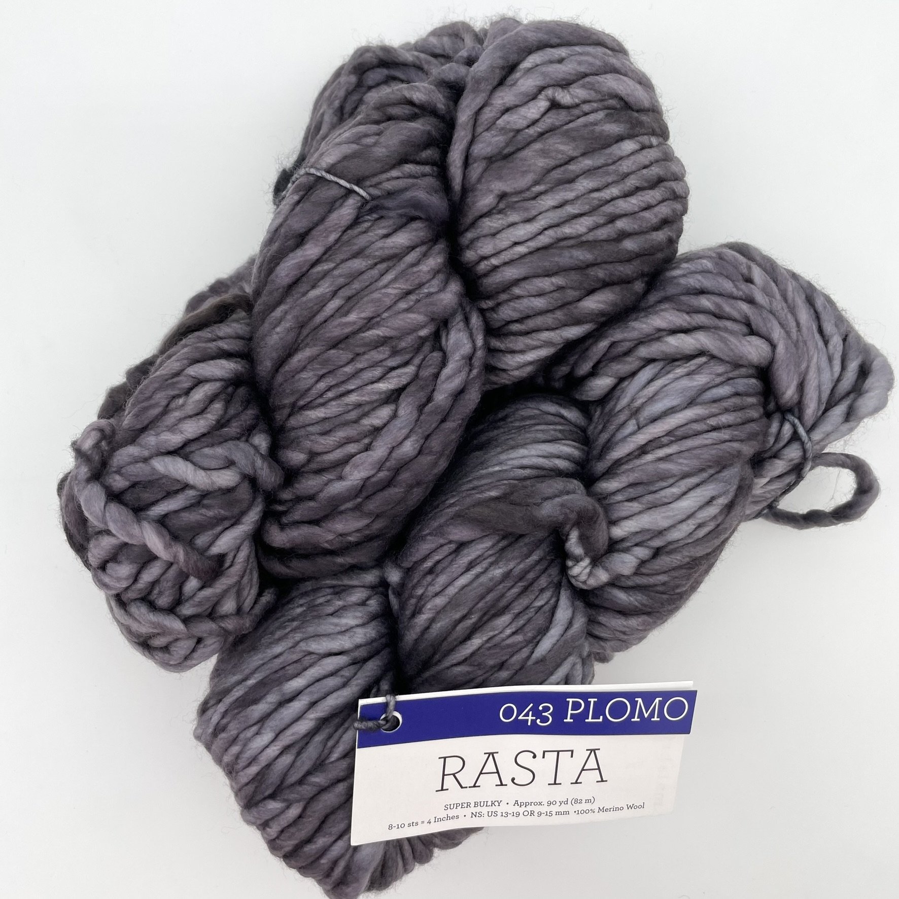Skein of Malabrigo Rasta yarn in Plomo color, with soft gray tones and super bulky texture, 100% Merino wool.