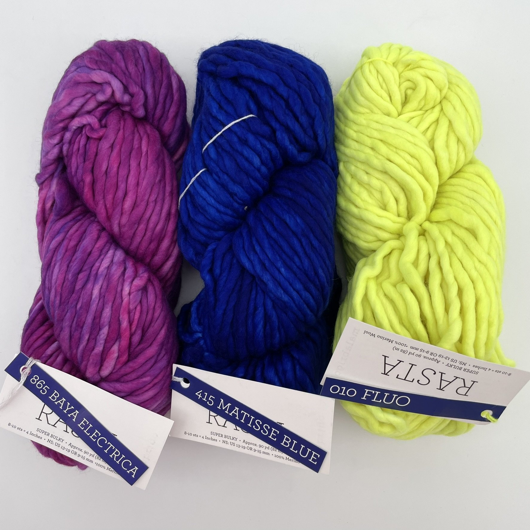 Three skeins of Malabrigo Rasta yarn in Baya Electrica, Matisse Blue, and Fluo colorways, super bulky merino wool perfect for vibrant projects.