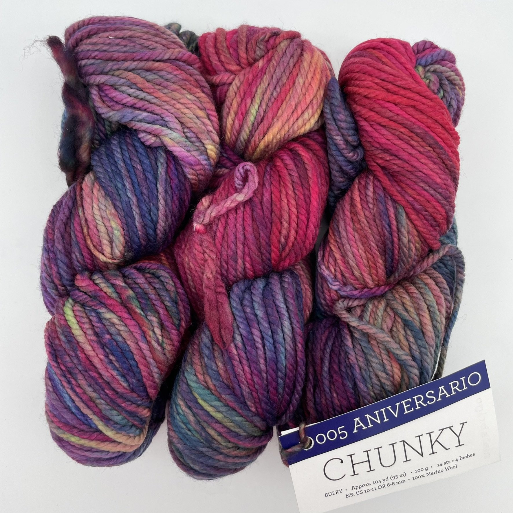 Malabrigo Chunky yarn in Aniversario colorway, featuring vibrant shades of red, purple, blue, and pink in bulky merino wool.