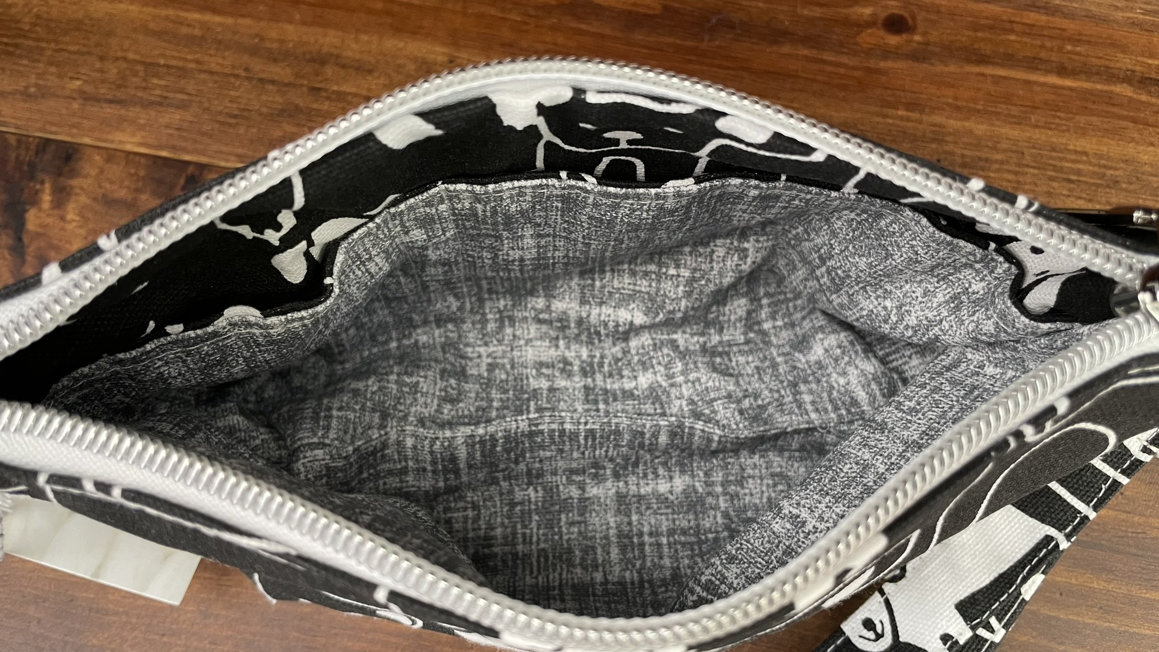 Zippered accessories pouch with a playful black and white dog print, featuring a spacious interior and sturdy construction.