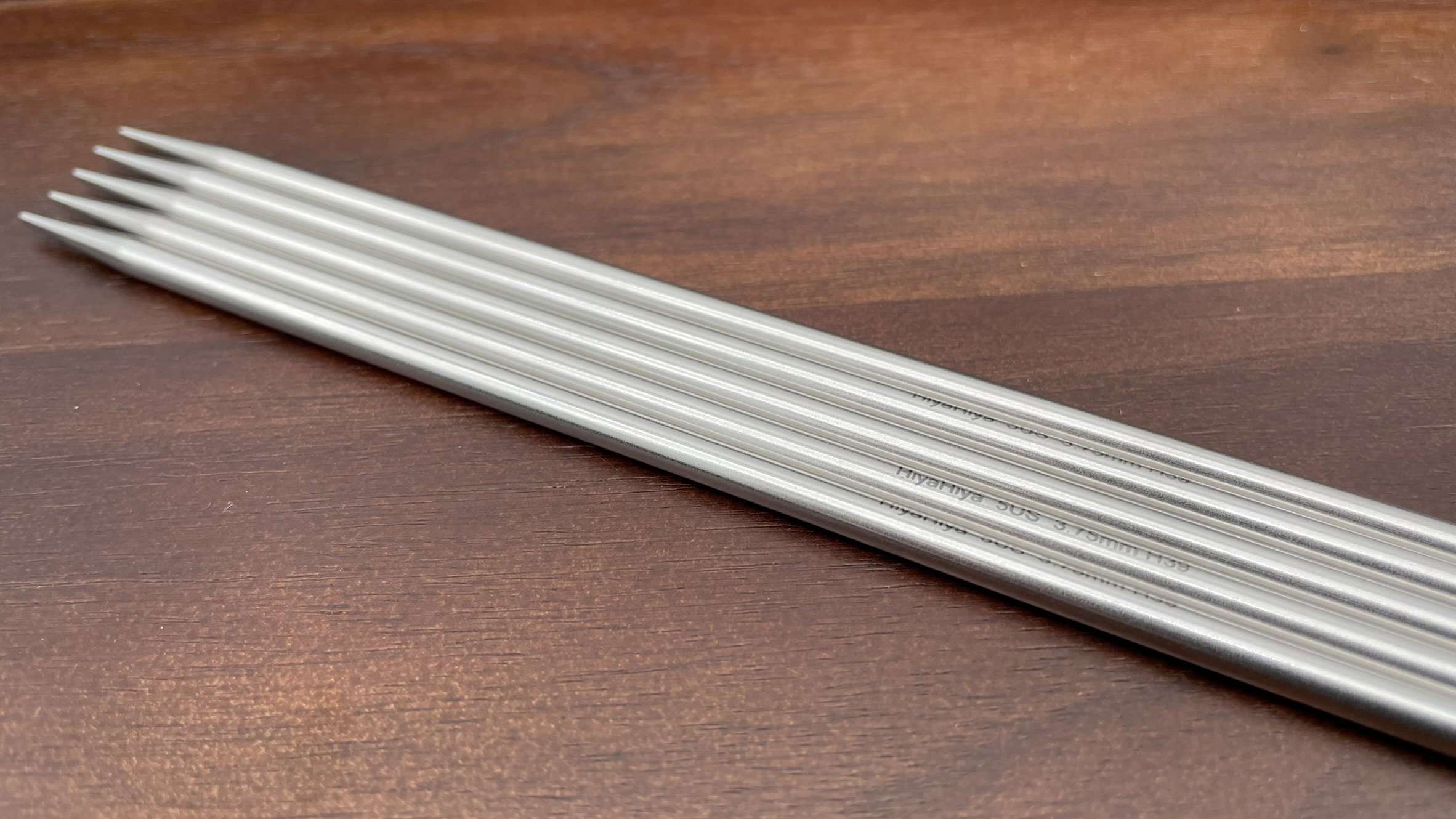 Close-up of HiyaHiya 8-inch steel double-pointed knitting needle with etched size information