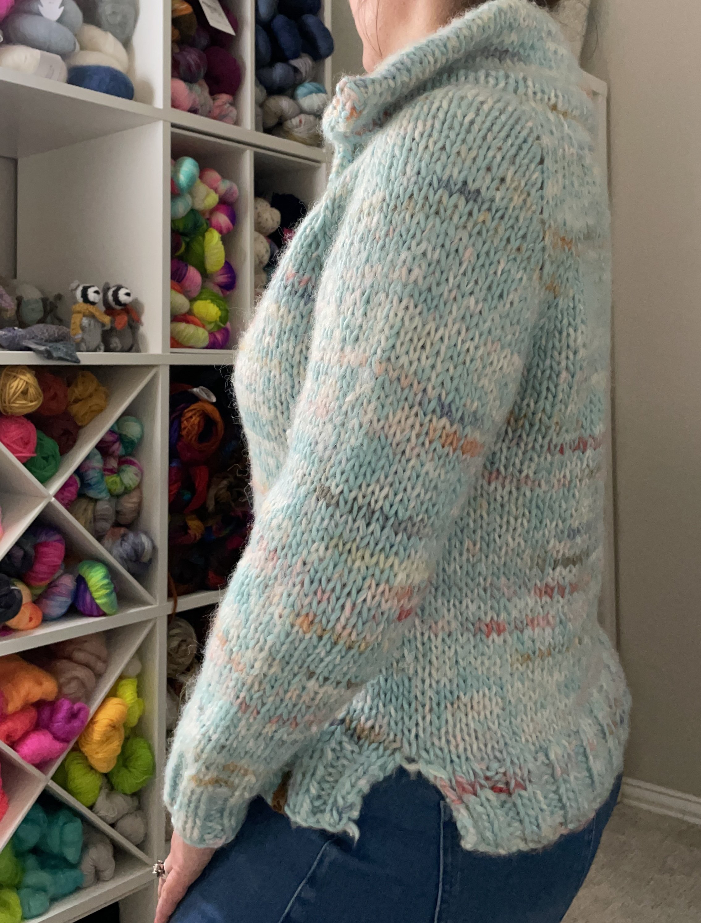 Side view of a hand-knit Wishlist pullover modeled, showcasing the relaxed fit and colorful yarn details.