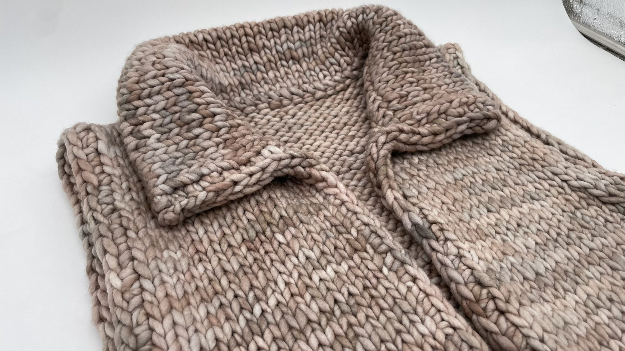 Detailed close-up of the collar on a hand-knit adventurer vest in soft, chunky yarn.