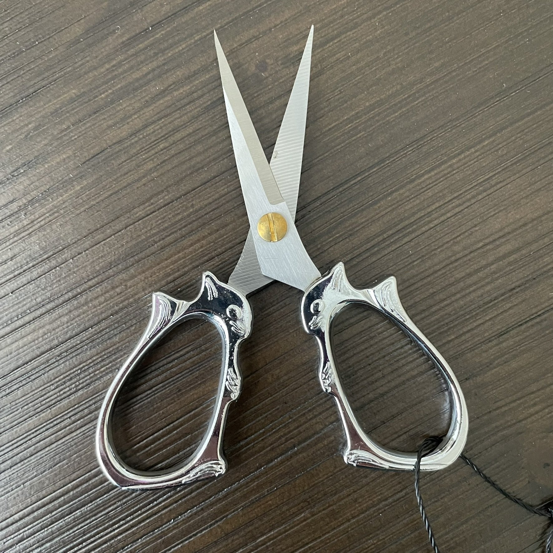 Silver squirrel embroidery scissors with vintage-inspired handles, ideal for detailed crafting, knitting, and embroidery projects.