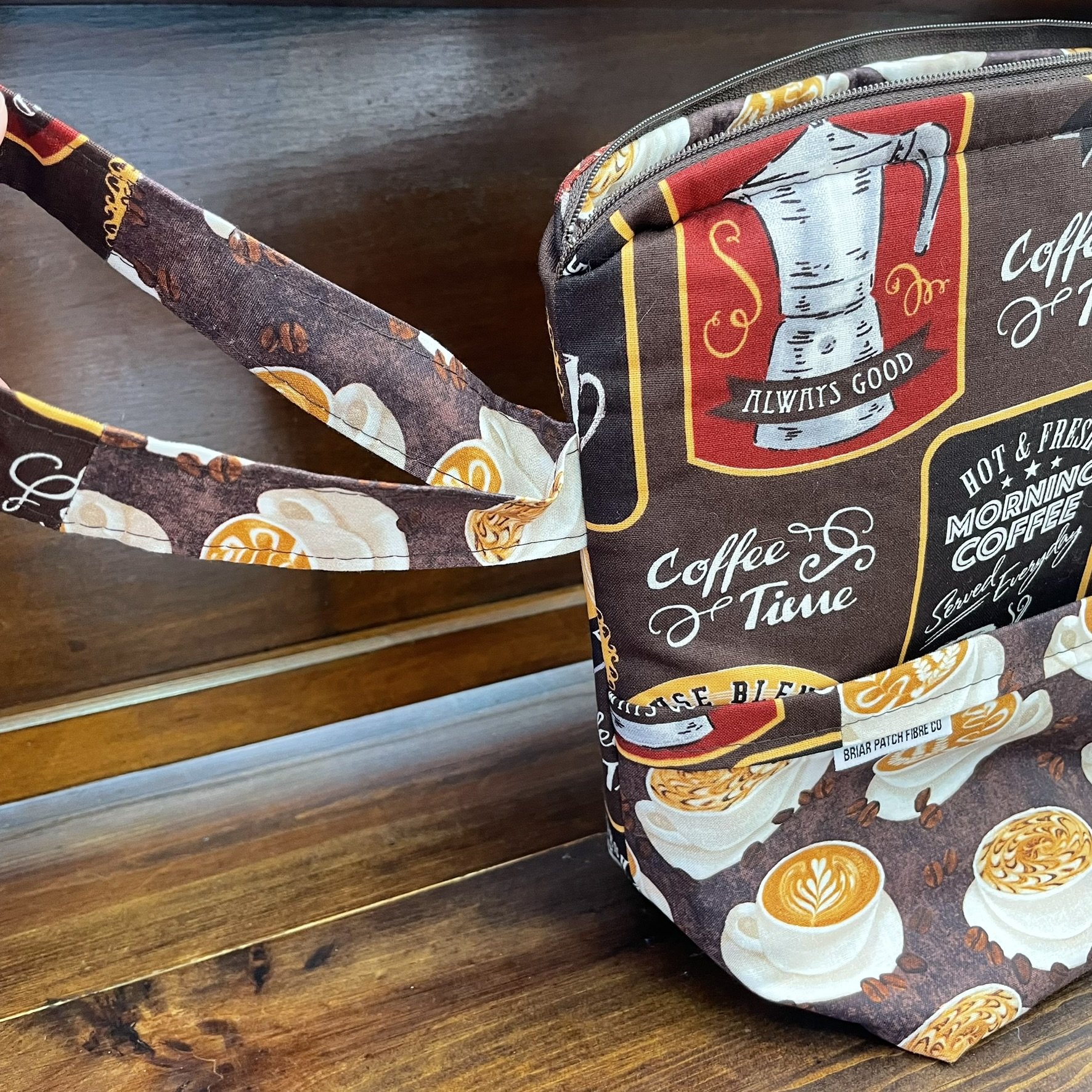 Top view of a large coffee-themed project bag, featuring a spacious interior with coffee cup and latte fabric patterns.