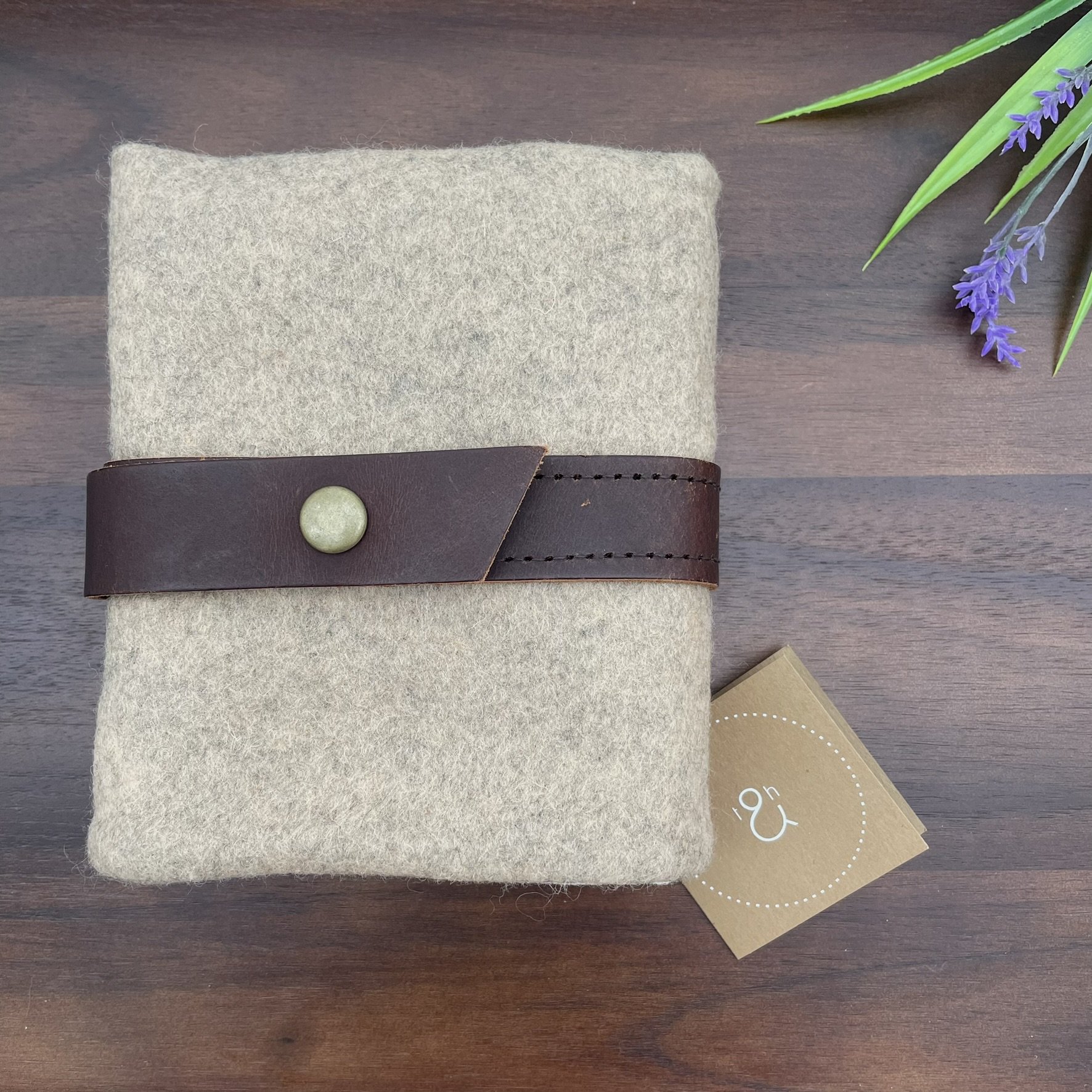 Top view of the Twig & Horn natural wool knitting tool pouch, featuring a zipper pocket and leather strap closure.