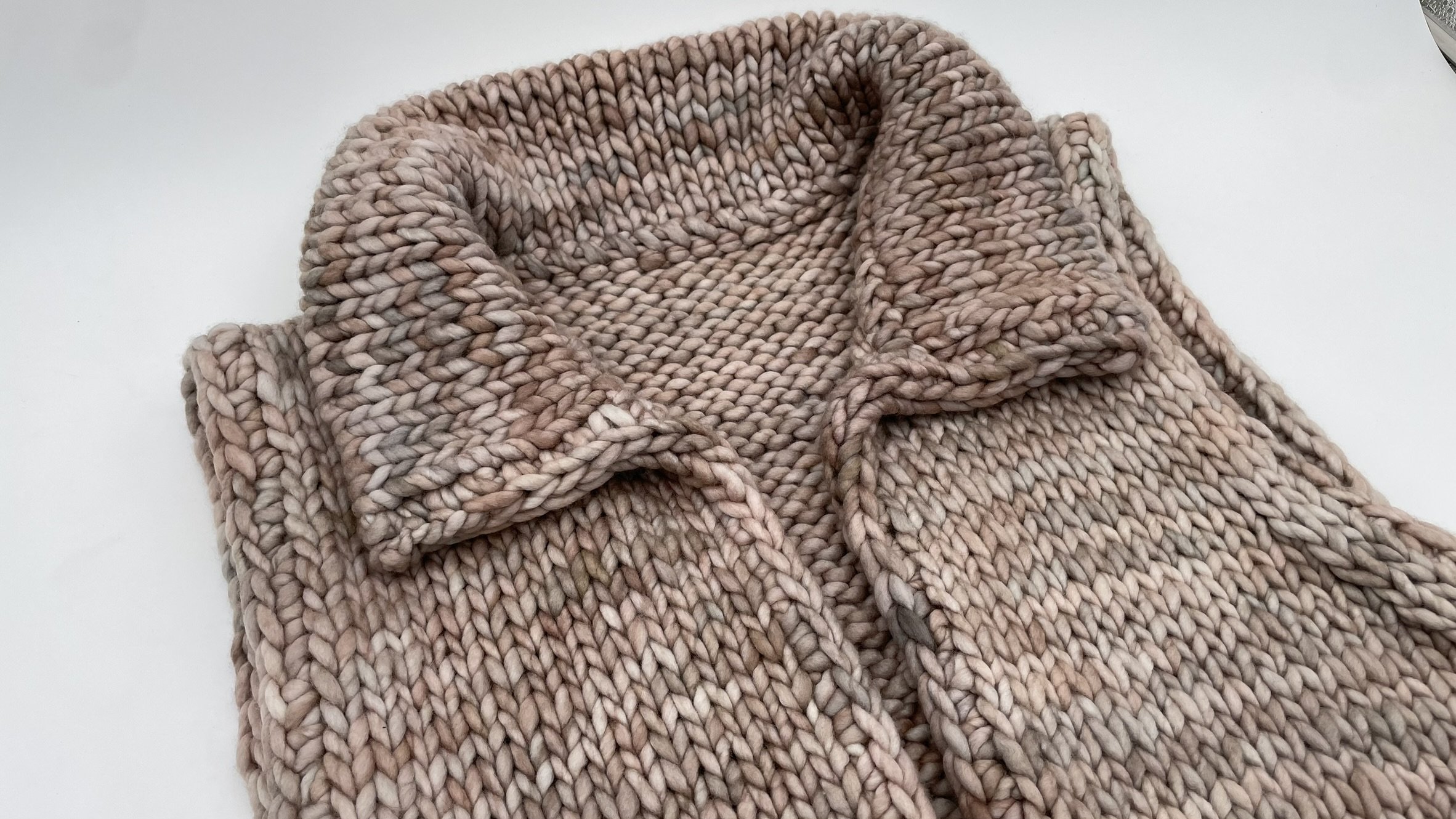 Top-down view of the collar on a hand-knit adventurer vest, showing detailed stitch work.